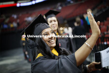 Kiran Sharma waves to family and friends during the processional. 2019 Spring Graduate Commencement 