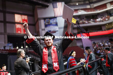 Jacob Andrews gestures to family and friends after receiving his College of Business diploma. Underg