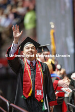 Helmuth Krische gestures to family and friends after receiving his College of Business diploma. Unde