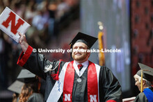 Cody McCain gestures to family and friends after receiving his College of Business diploma. Undergra