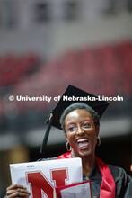 Jewel Rodgers gestures to family and friends after receiving her College of Business diploma. Underg