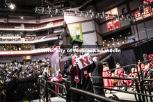 Benjamin Vaske gestures to family and friends after receiving his College of Business diploma. Under