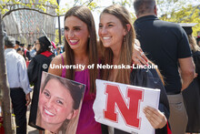 Hailey Lehms poses with her sister, Lindsey, after the commencement. Her family held up large photos