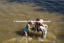 Kayla Vondracek, Jessica Corman and Matthew Chen look over a sand sample in the Niobrara River. Jess