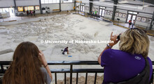 Visitors watch from an observation deck as Raymond Dierdorf, an intern at the park, removes layers o