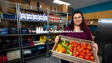Morgan Smith, a graduate research assistant, shows a tote of fresh vegetables available at Husker Pa