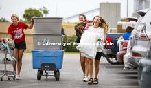 From left: Kealey Franzen, Avery Franzen and McKenna Beezley laugh as they move into their Schramm H