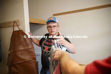 Tristan Smith, from Curtis, Nebraska, grabs a handful of clothes to hang. Massengale Residential Cen