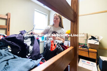 Abi Schoup hangs up clothes in her room. Abi is a freshman in the Honors program. She is originally 