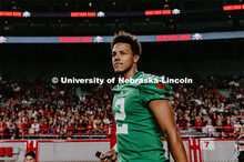 Husker Quarterback, Adrian Martinez talking to students. Student making a catch and the team going w