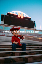 Herbie sitting in the bleachers. Herbie Husker photo shoot, pictured throughout Memorial Stadium. Se