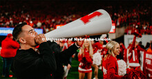 Male cheerleader using megaphone to pump up crowd at the Nebraska vs. Ohio State University football