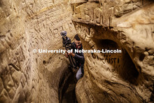 Dylan Downes, a sophomore in civil engineering from Lincoln, carries the tripod through a passage af
