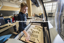 Carly Brotherson pulls sock blocks from the laser cutter at Nebraska Innovation Studio Nov. 25. Brot