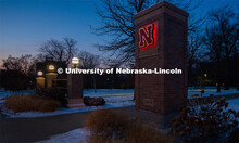 As the sun sets, the East Campus gateway / entrance columns are lit up and surrounded by snow. Decem