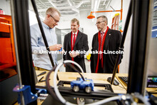 Shane Farritor shows NU President Ted Carter and UNL Chancellor Ronnie Green a 3D printed part for h