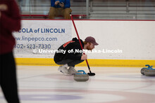 Colin Wooldrik of the UNL Curling Team is looking over the stones in the house (the scoring area) to