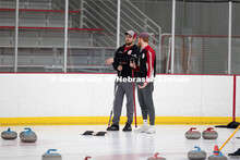 Colin Wooldrik in the purple cap and Adam Schlichtmann in the red and gray cap discuss options for t