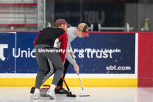 Colin Wooldrik in the purple cap and Jordan Monk in the gray long sleeve shirt of the UNL Curling Te
