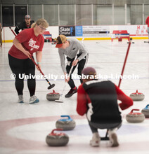 Colin Wooldrik squatting yells sweeping instruction to Anna Fiala and Jordan Monk. Nebraska's nation