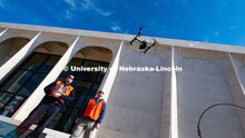 Berry Scott (from left) and Matt Raiter fly a drone outside Sheldon Museum of Art. The drones are us