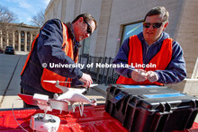 Berry Scott (from left) and Matt Raiter assemble a drone outside Sheldon Museum of Art. This flight 