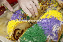 A Mardi Gras King Cake is sliced for diners. Mardi Gras special meal at East Campus Dining Center. F