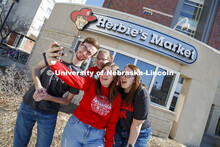 Harper Dining Center photo shoot. Students snap a selfie outside Herbie’s Market near Harper Dinin