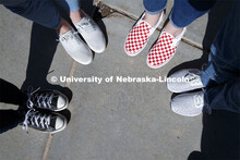 Harper Dining Center photo shoot. Students feet with fancy red and white checked Vans shoes. March 3