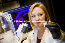 Morgan Schake examines a slide. She is a graduate student in the lab of Ryan Pedrigi, Assistant Prof