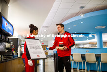 Zachery Borer, a freshman from North Bend, NE, collects his drink and lunch to-go from Manpreet Kaur