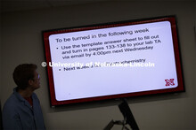Bailey McLean, junior in biological sciences, watches a PowerPoint slide as he helps with the record