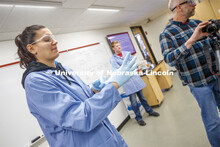 Jessica Periago, chemistry department lab manager, puts on protective gloves before she records a Ch
