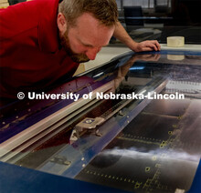 Jerry Reif, shop manager at Nebraska Innovation Studio, works on a laser to cut clear plastic sheeti
