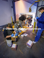 University employees sort packages after a morning delivery at the Facilities Management Shops on N.