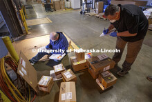 Pat Huberty (from left) and Ed Kearney check in and sort packages following a Monday morning FedEx d