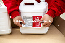 Sarah Herzinger applies labels to the hand sanitizer. Hand sanitizer is being made at Nebraska Innov