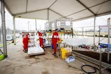 Hand Sanitizer is mixed and loaded into jugs inside a fenced off section of the Food Innovation Cent
