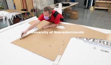 Jerry Reif, shop manager at Nebraska Innovation Studio, cuts hospital gowns from Tyvec material hous