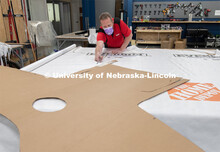 Jerry Reif, shop manager at Nebraska Innovation Studio, cuts hospital gowns from Tyvec material hous