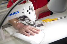 Jerry Reif, shop manager at Nebraska Innovation Studio, cuts hospital gowns from Tyvec material hous