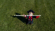 Herbie Husker proudly holds a diploma and is decked out in graduation attire for the Spring Commence