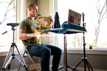 Justin Mohling, a second year master’s student, plays his French horn while remote learning in his