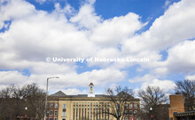 Fluffy clouds dot the sky above Love Library on City Campus looking north on 13th Street. April 14, 