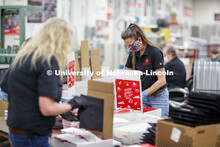 Paula Wenzl packs a Go Big Grad box Friday morning. Printing Service employees work to fill the Go B