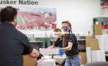 Paula Wenzl finishes a Go Big Grad box Friday morning. Printing Service employees work to fill the G