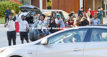 Rwandan graduates and undergraduates wave to the parade as it circles University Suites Friday eveni
