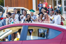 Rwandan graduates and undergraduates wave to the parade as it circles University Suites Friday eveni