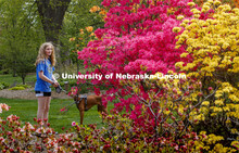 Jordan Renard and her dog pause to look at a Rosy Lights Azalea which is lighting up East Campus' Ma