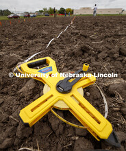 Tape measures are used to keep the row spacing accurate. James Schnable's group hand plants corn and